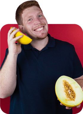 Jovem segurando um melão sorridente, em forma de telefone Jovem segurando um melão sorridente, em forma de telefone